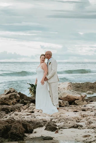 groom and bride at rocky beach