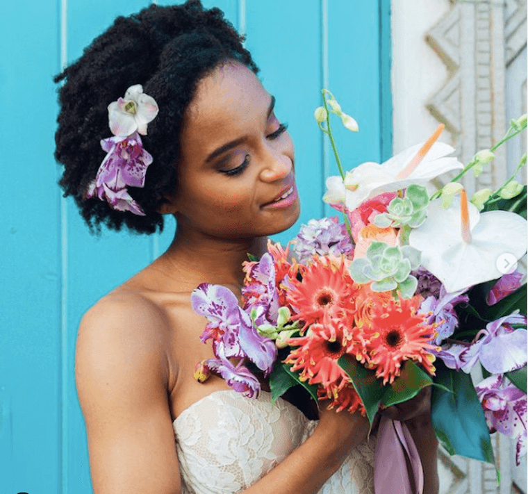 bride holding bouqet with flowers in hair