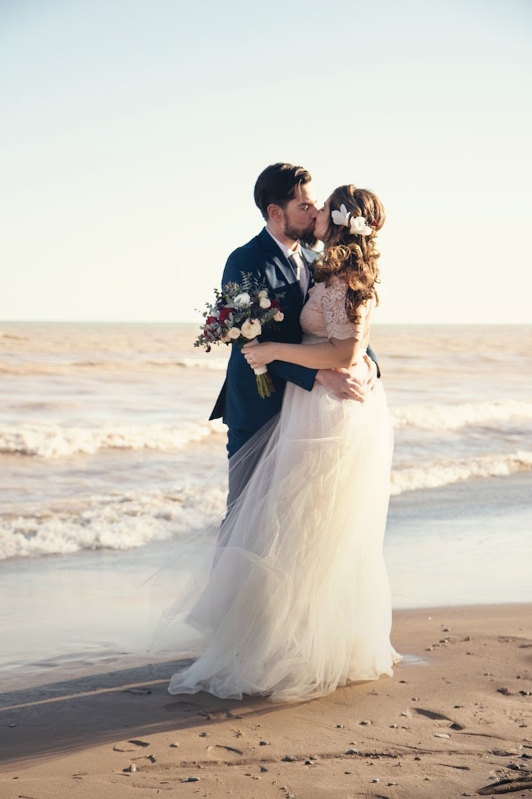 bride and groom kissing on beach wedding 