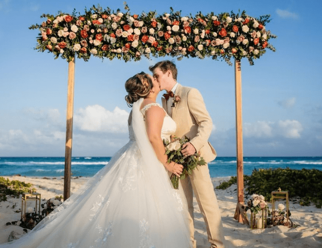 bride and groom kissing on the beach