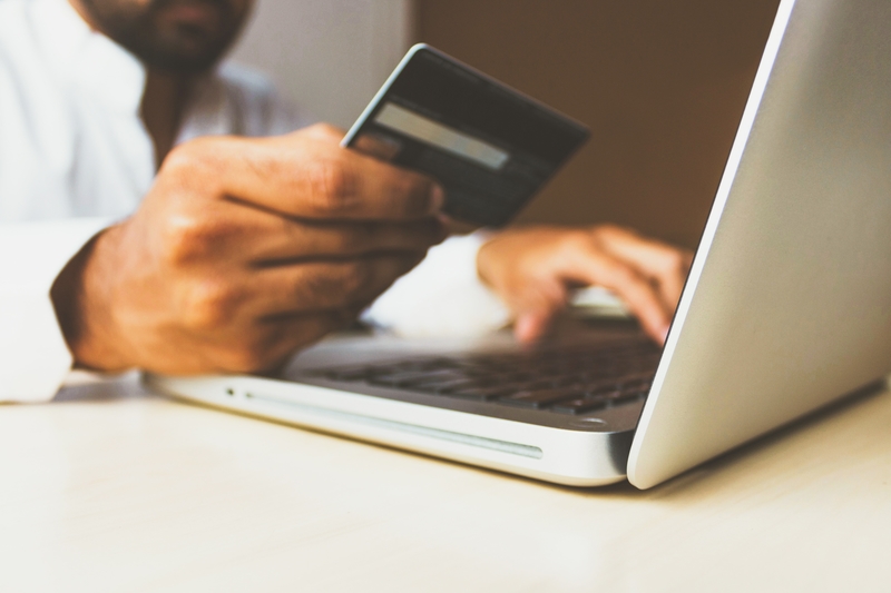 man holding credit card laptop