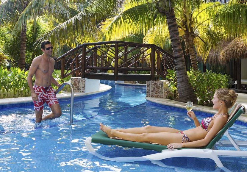 couple lounging in the lazy river at El Dorado Casitas Royale