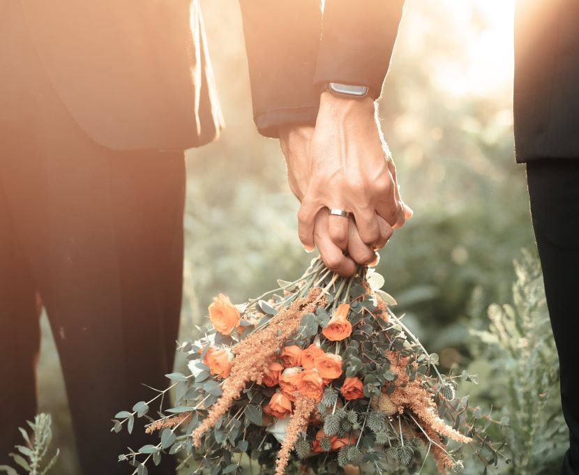 Gay couple holding bouquet 