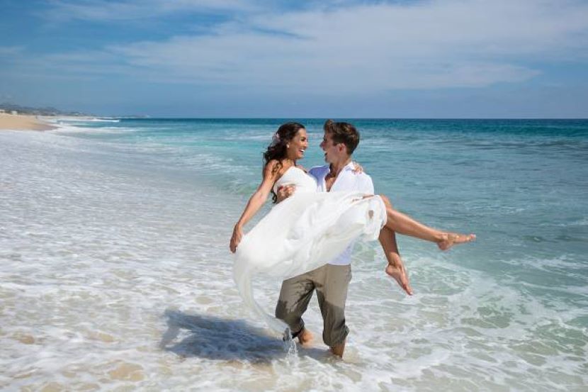 bride and groom in the ocean at Hyatt Ziva Los Cabos