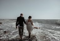 bride and groom playing in the sea