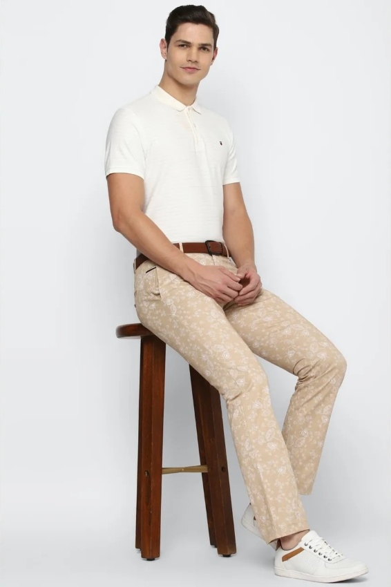 man wearing patterned trousers and white shirt
