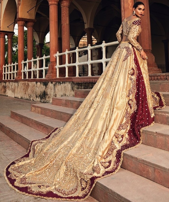 bride wearing long trail lehenga