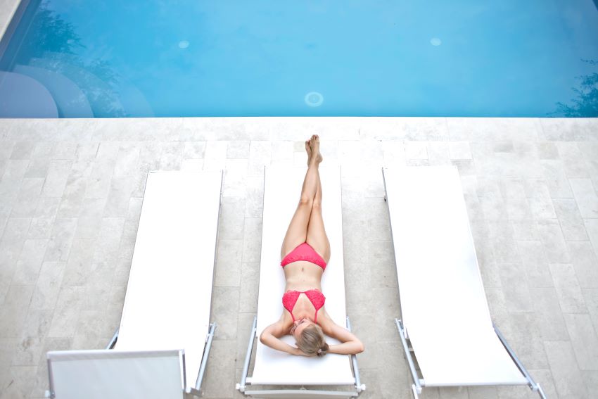 woman on sun lounger near a pool