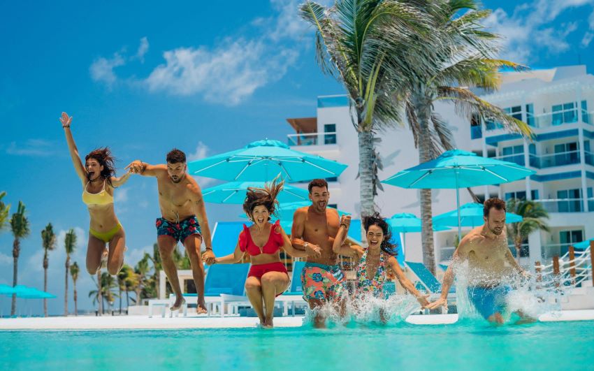 friends jumping in the pool at margaritaville island reserve cap cana