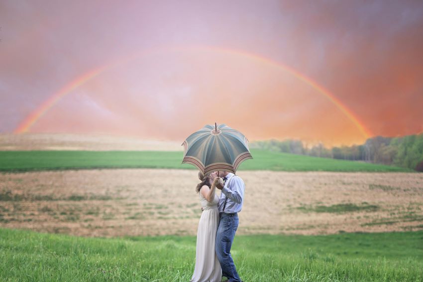 newlyweds kissing under an umbrella