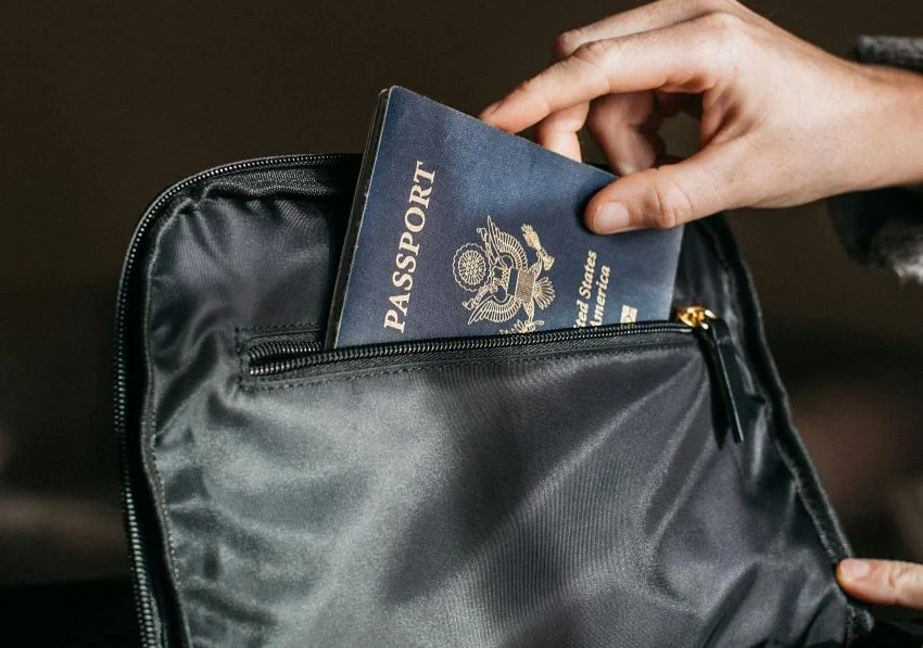 person keeping passport in bag