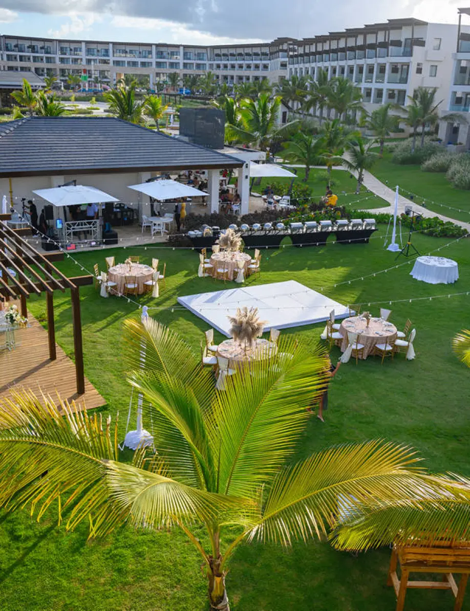 Garden wedding reception setup with dance floor and round tables at Dreams Macao Beach, Punta Cana