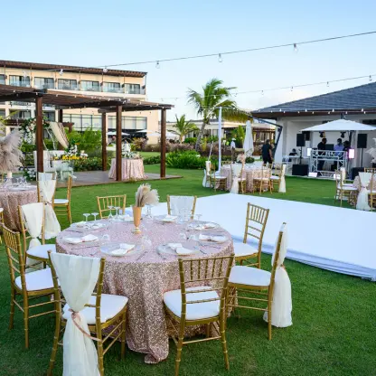 Garden wedding reception with gold chairs and a white dance floor at Dreams Macao Beach, Punta Cana