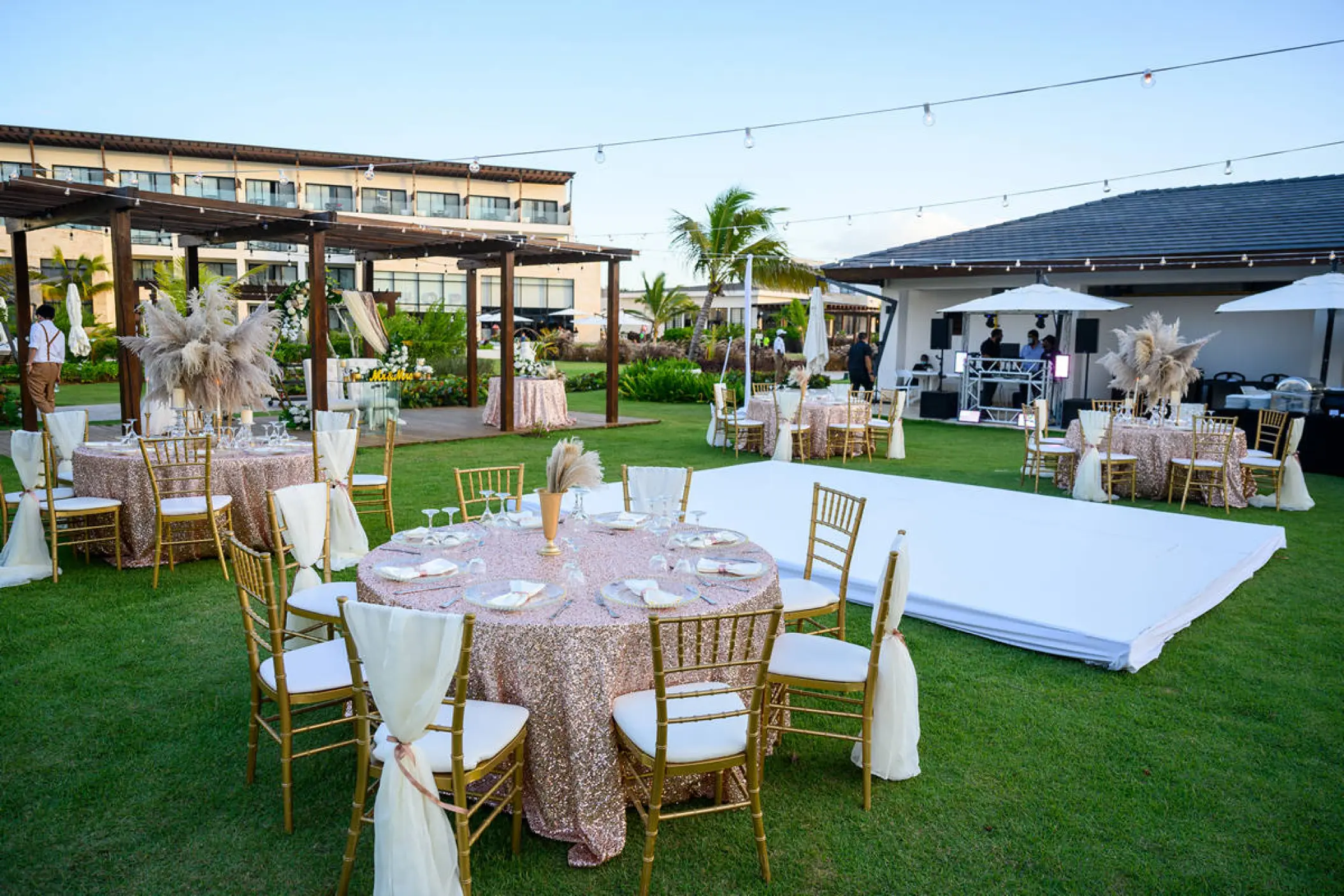 Garden wedding reception with gold chairs and a white dance floor at Dreams Macao Beach, Punta Cana