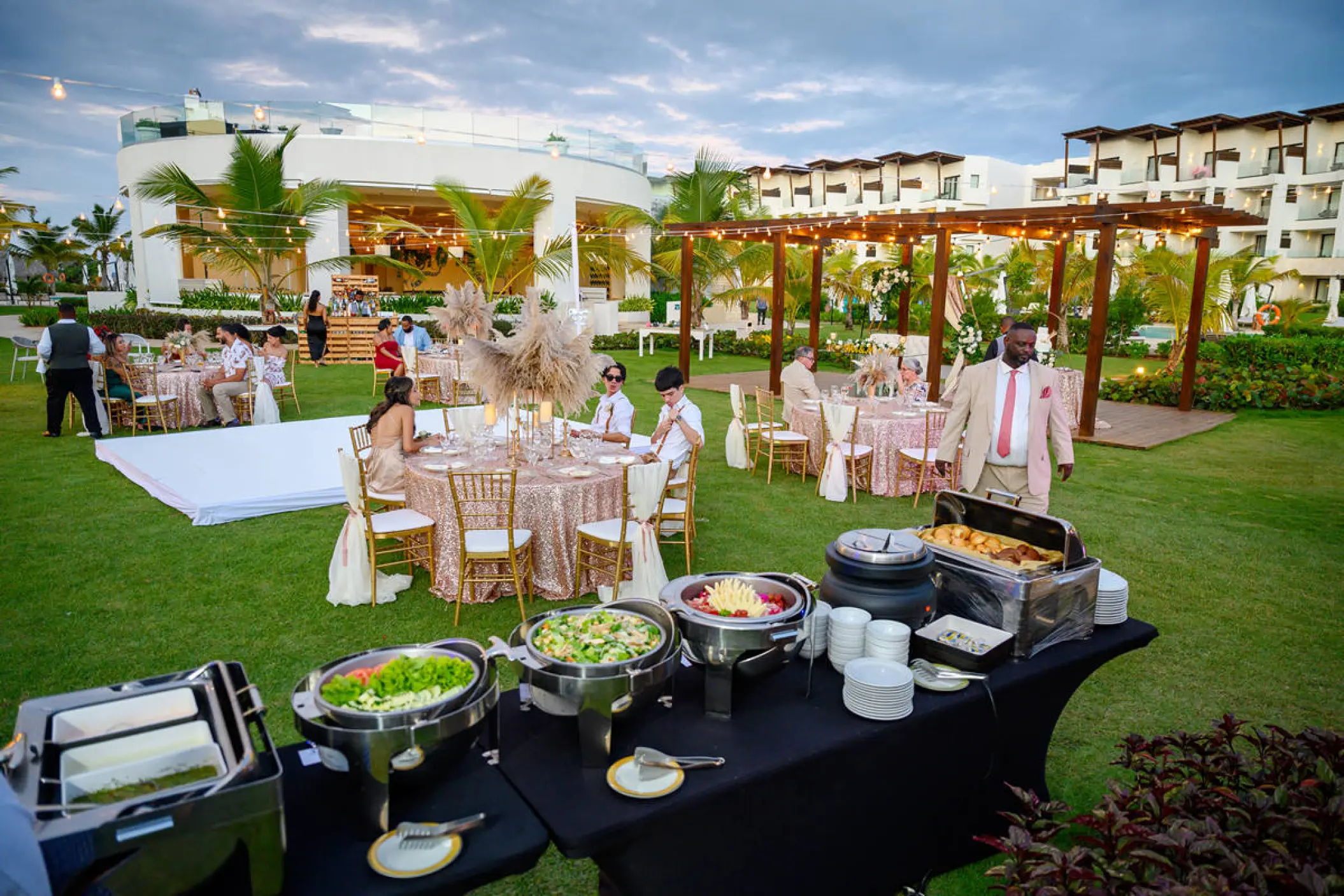 Outdoor wedding reception with buffet and dinner tables on the lawn at Dreams Macao Beach, Punta Cana