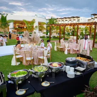 Outdoor wedding reception with buffet and dinner tables on the lawn at Dreams Macao Beach, Punta Cana