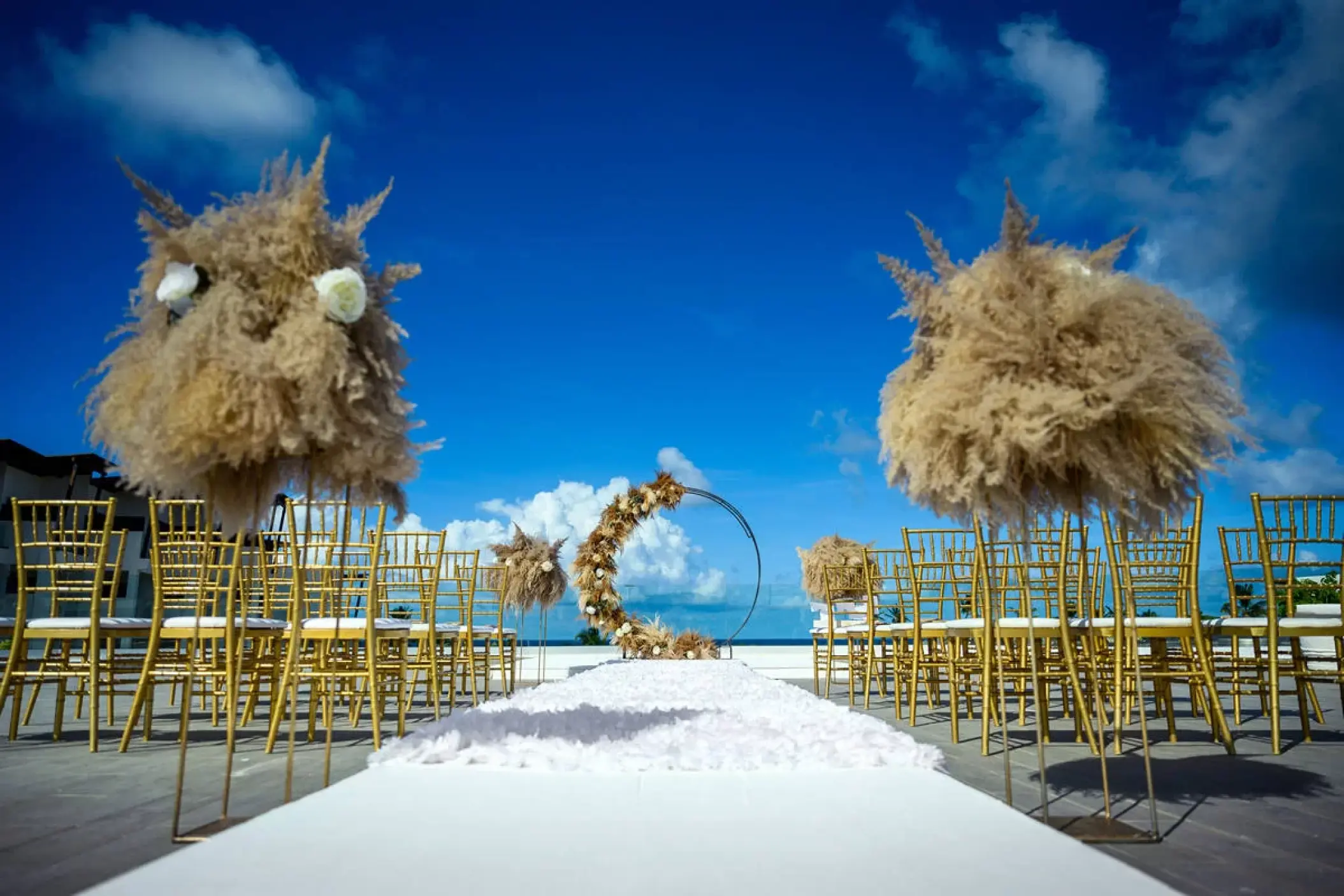 Rooftop wedding ceremony with pampas grass and gold chairs at Dreams Macao Beach, Punta Cana