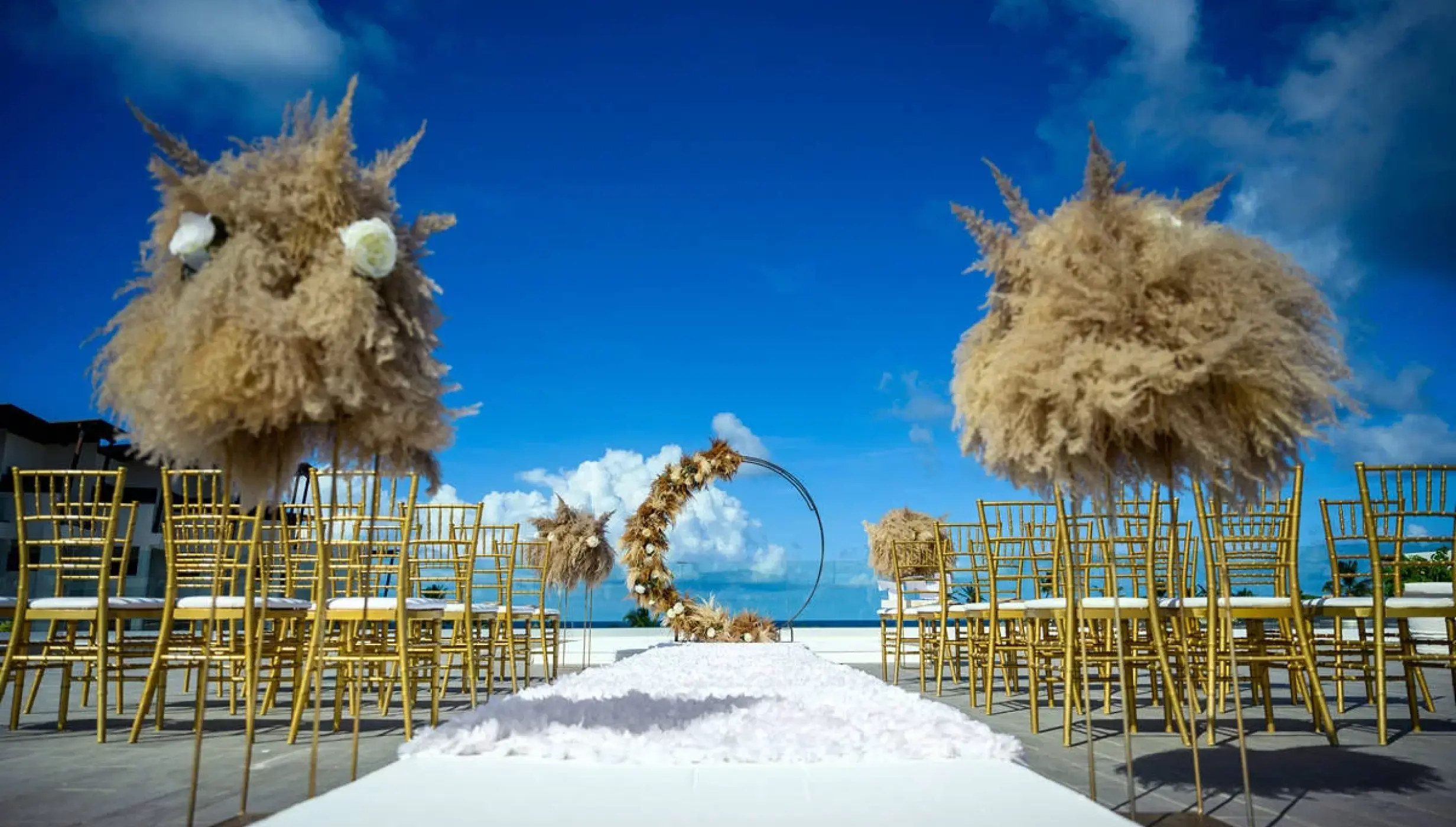 Rooftop wedding ceremony with pampas grass and gold chairs at Dreams Macao Beach, Punta Cana