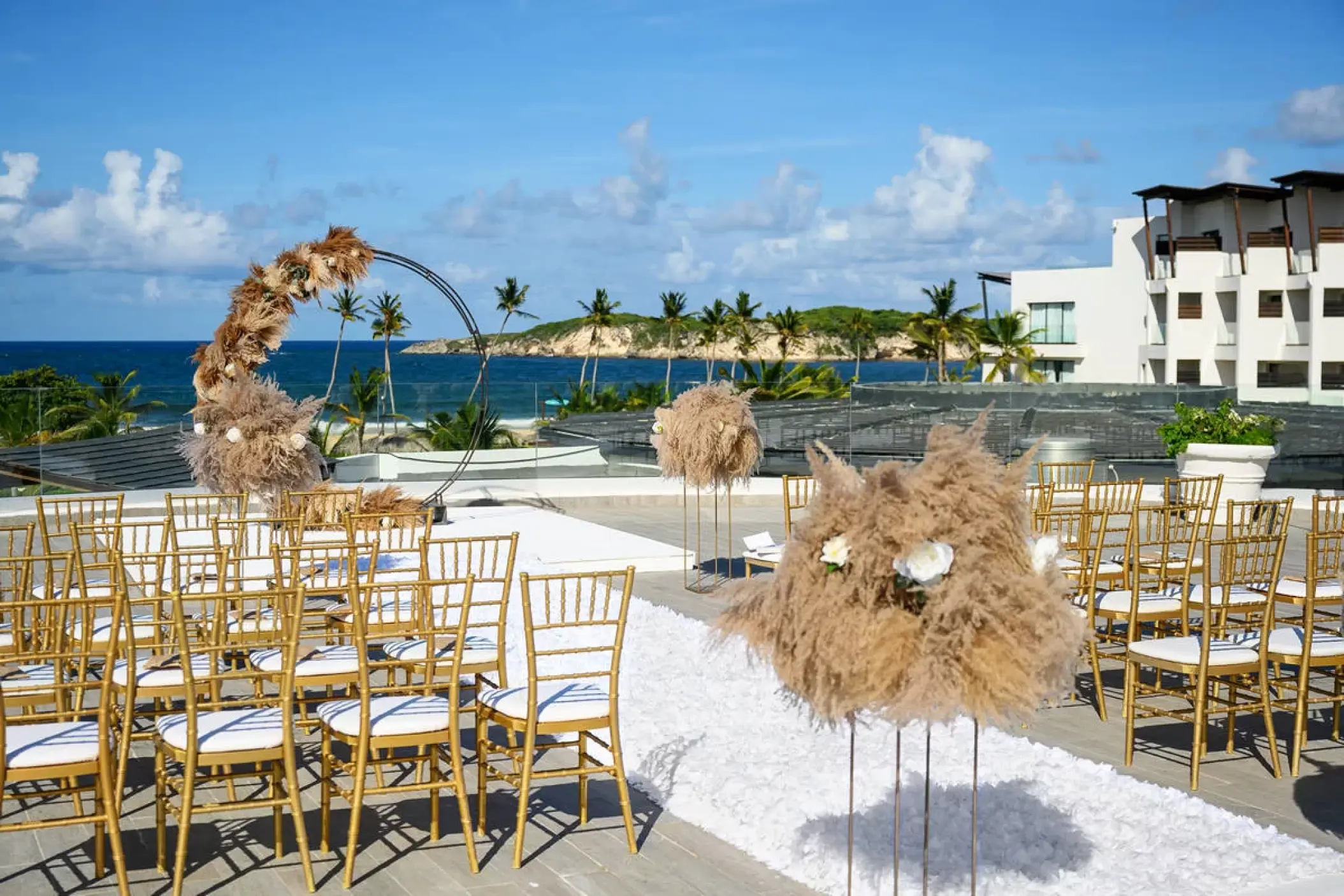 Rooftop wedding ceremony with gold chairs and pampas grass at Dreams Macao Beach, Punta Cana