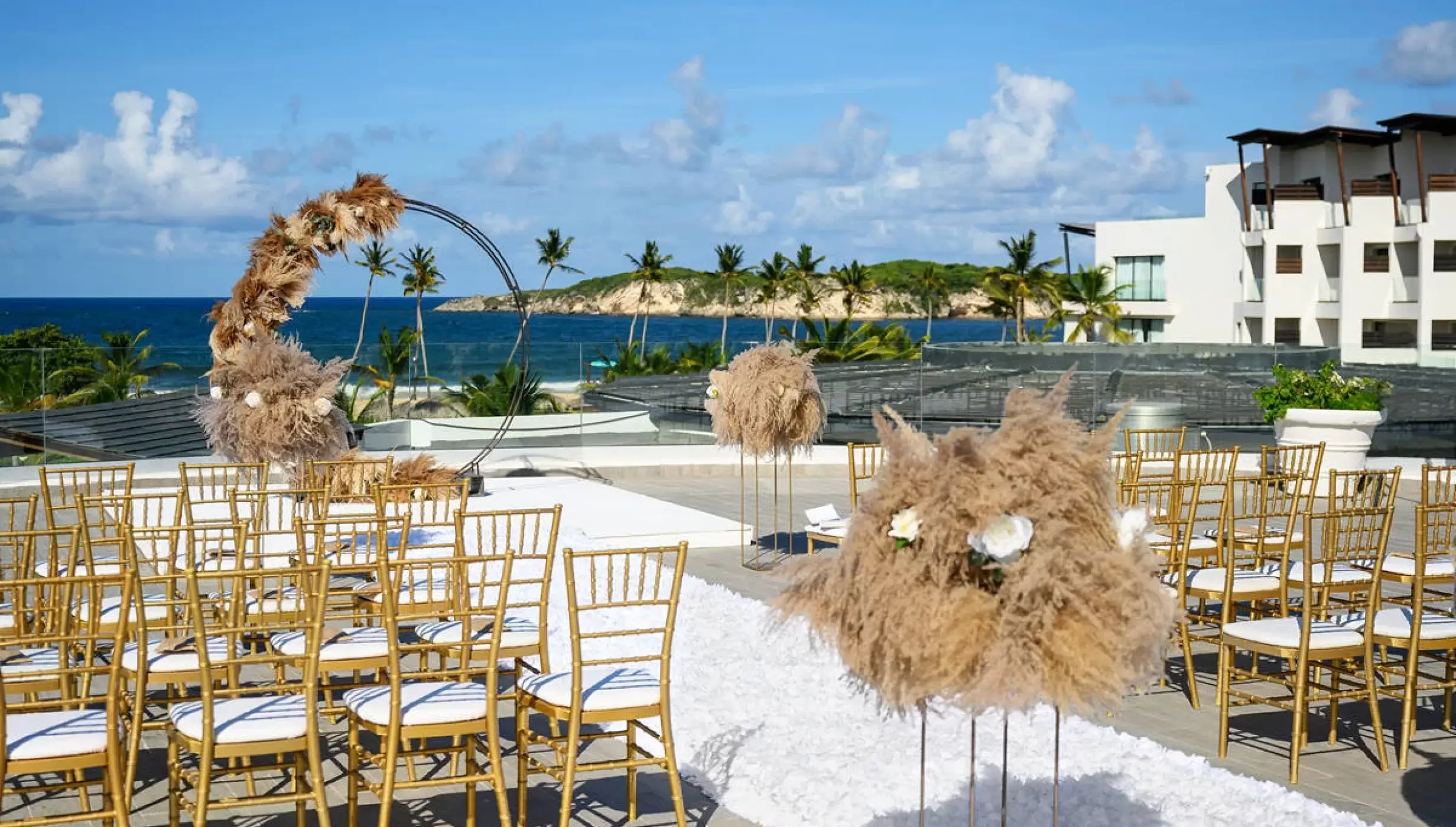 Rooftop wedding ceremony with gold chairs and pampas grass at Dreams Macao Beach, Punta Cana