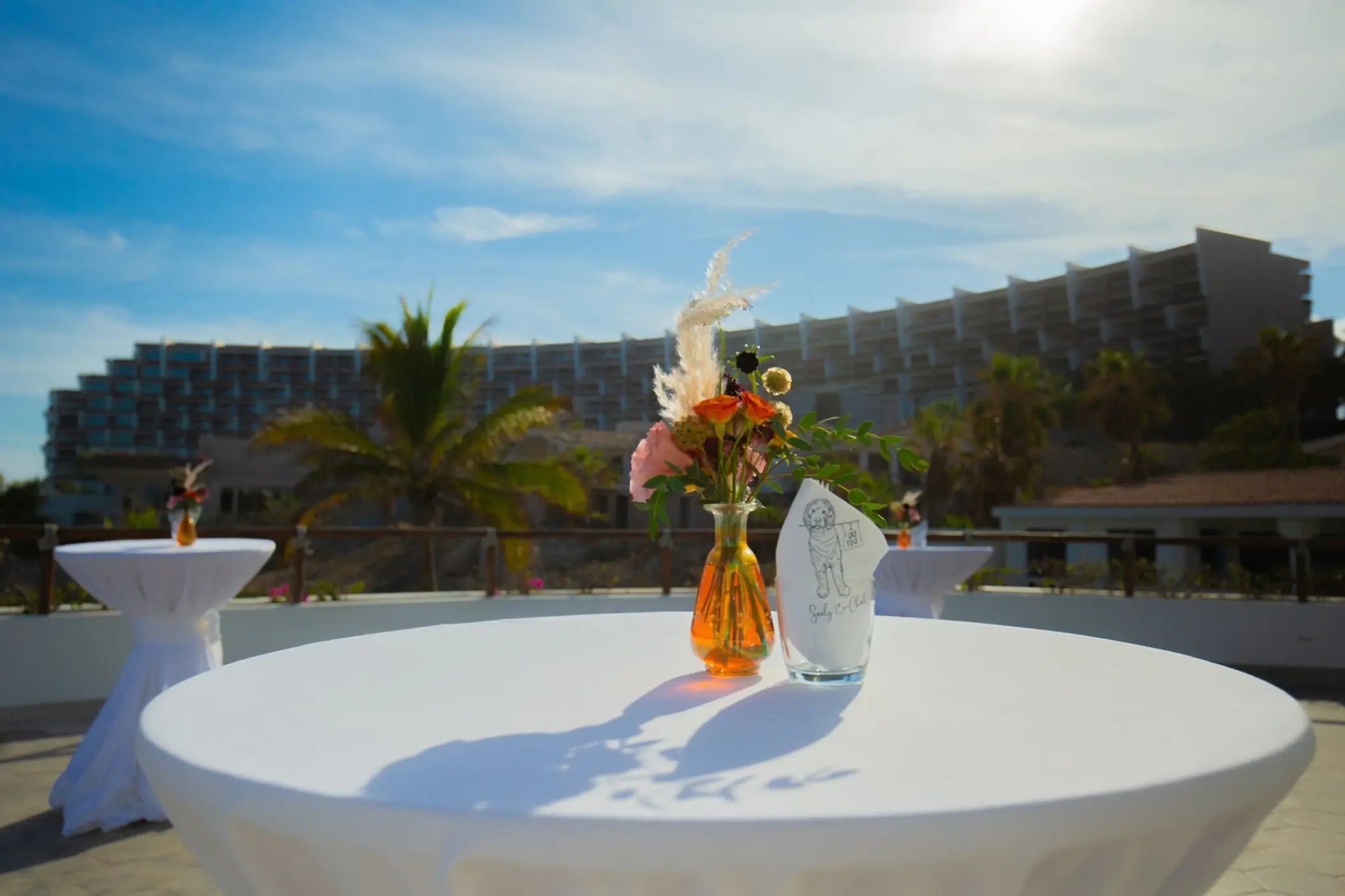 Cocktail tables with floral centerpieces on the Encanto Terrace at Mar Del Cabo, Cabo San Lucas