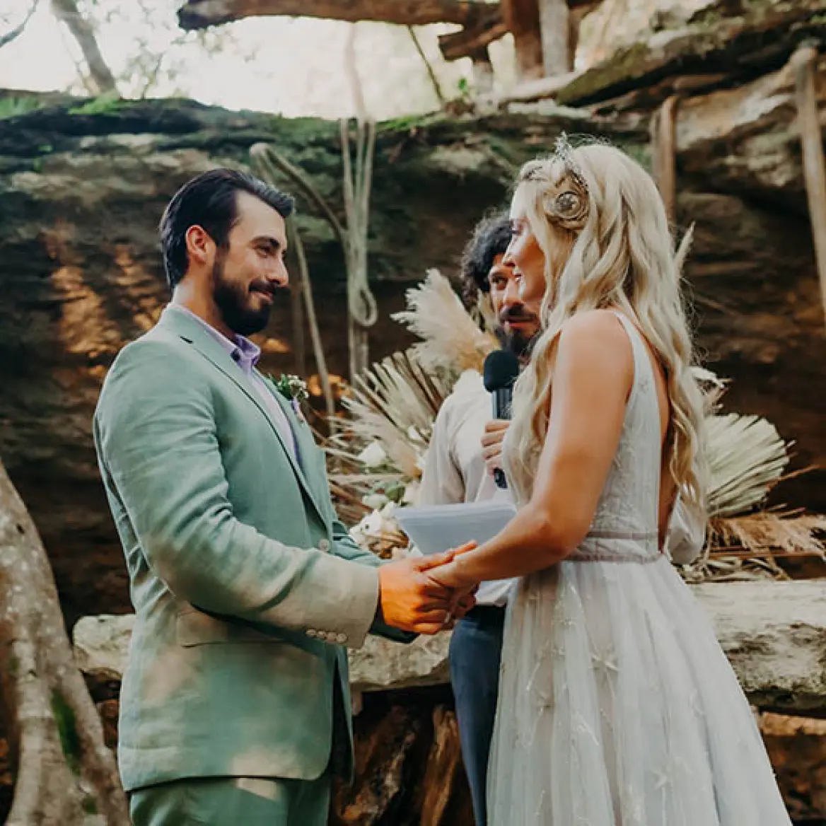 The bride and groom holding hands during an intimate cenote wedding ceremony in the Riviera Maya