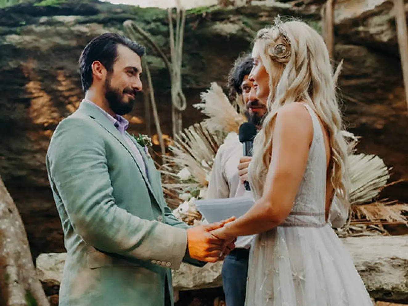 The bride and groom holding hands during an intimate cenote wedding ceremony in the Riviera Maya