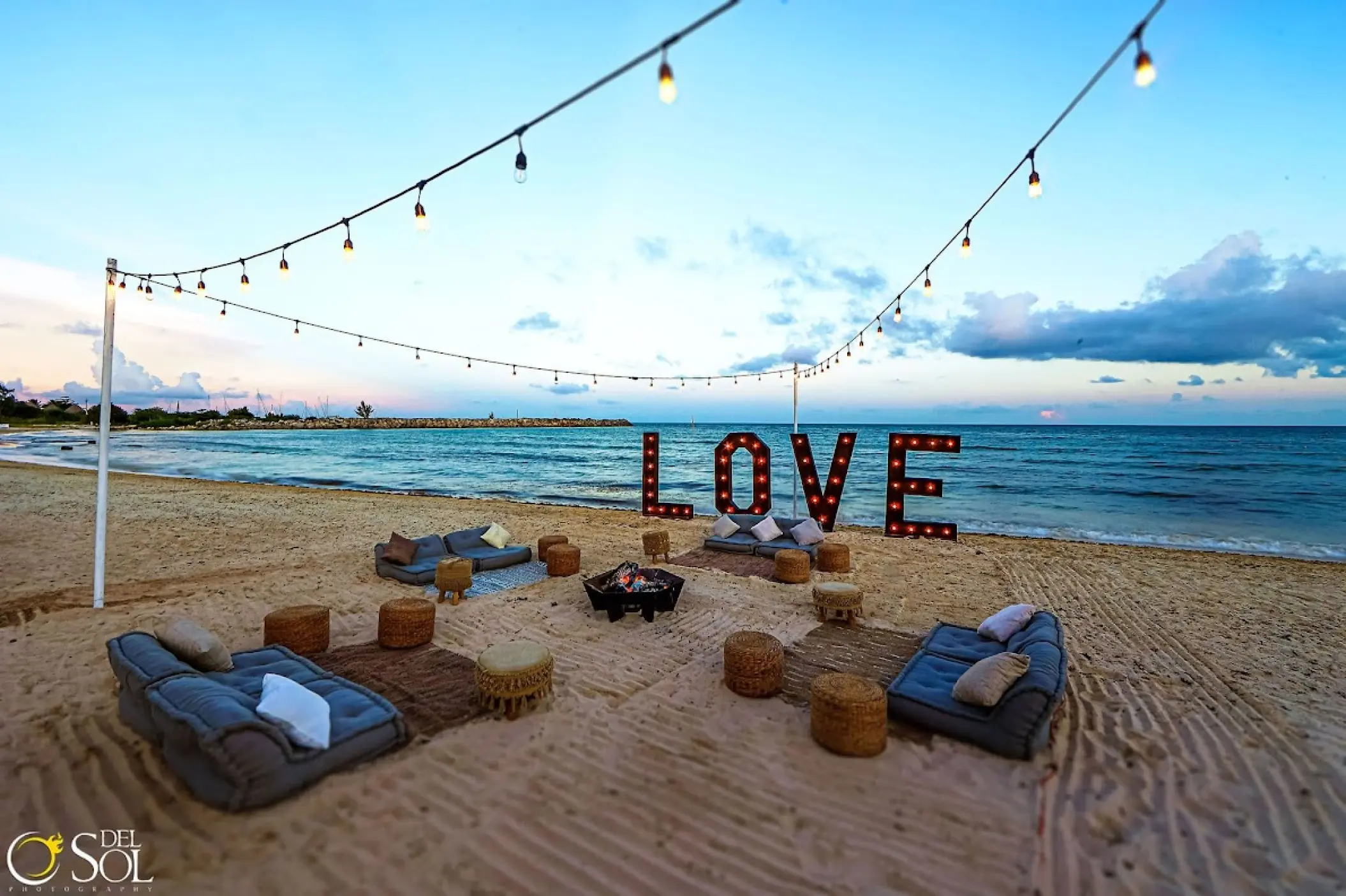 Beachfront wedding reception with LOVE marquee letters and lounge seating at Dreams Jade, Riviera Maya