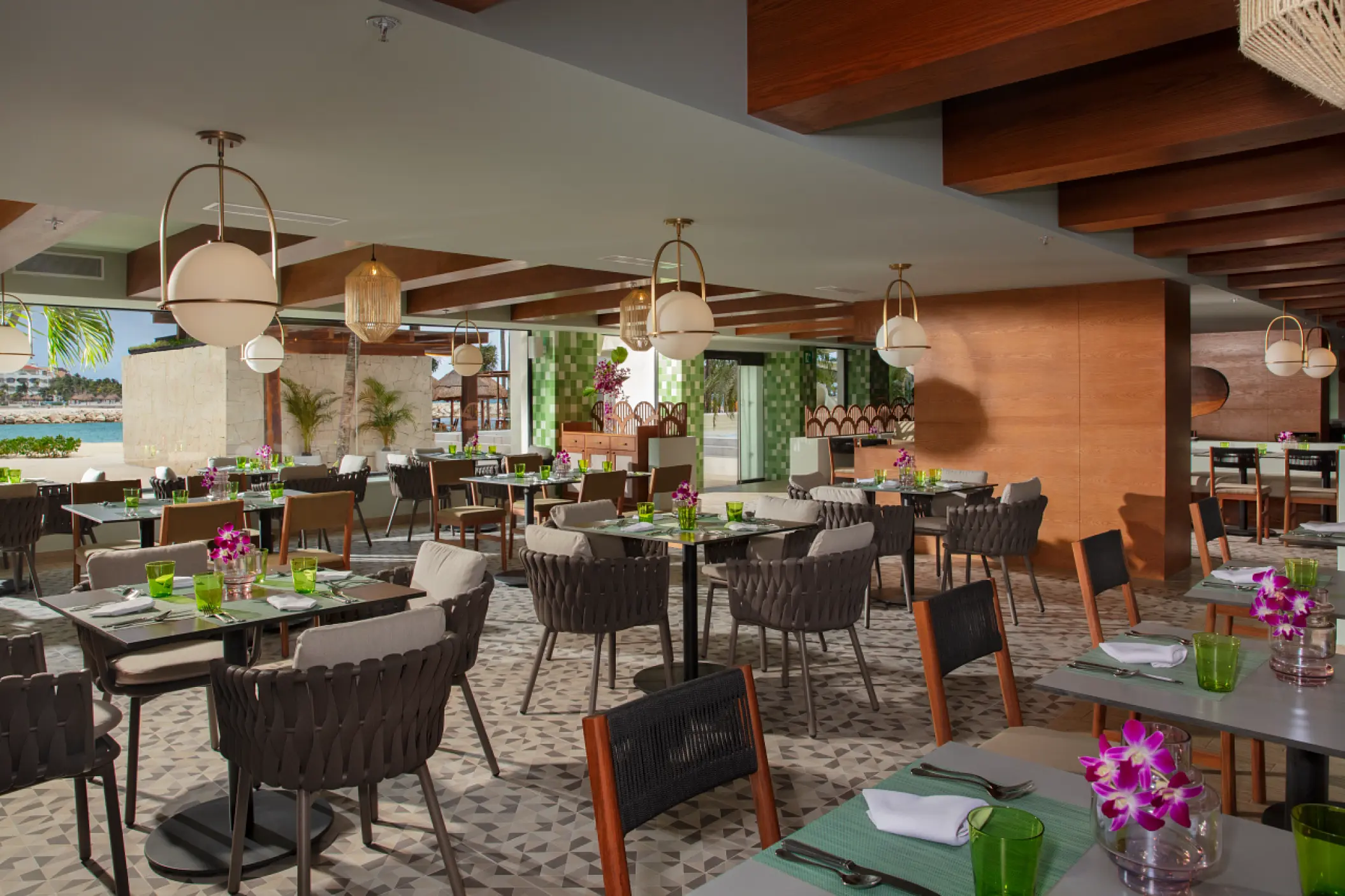 Modern open-air restaurant with globe pendant lighting and wooden accents at Dreams Aventuras, Riviera Maya
