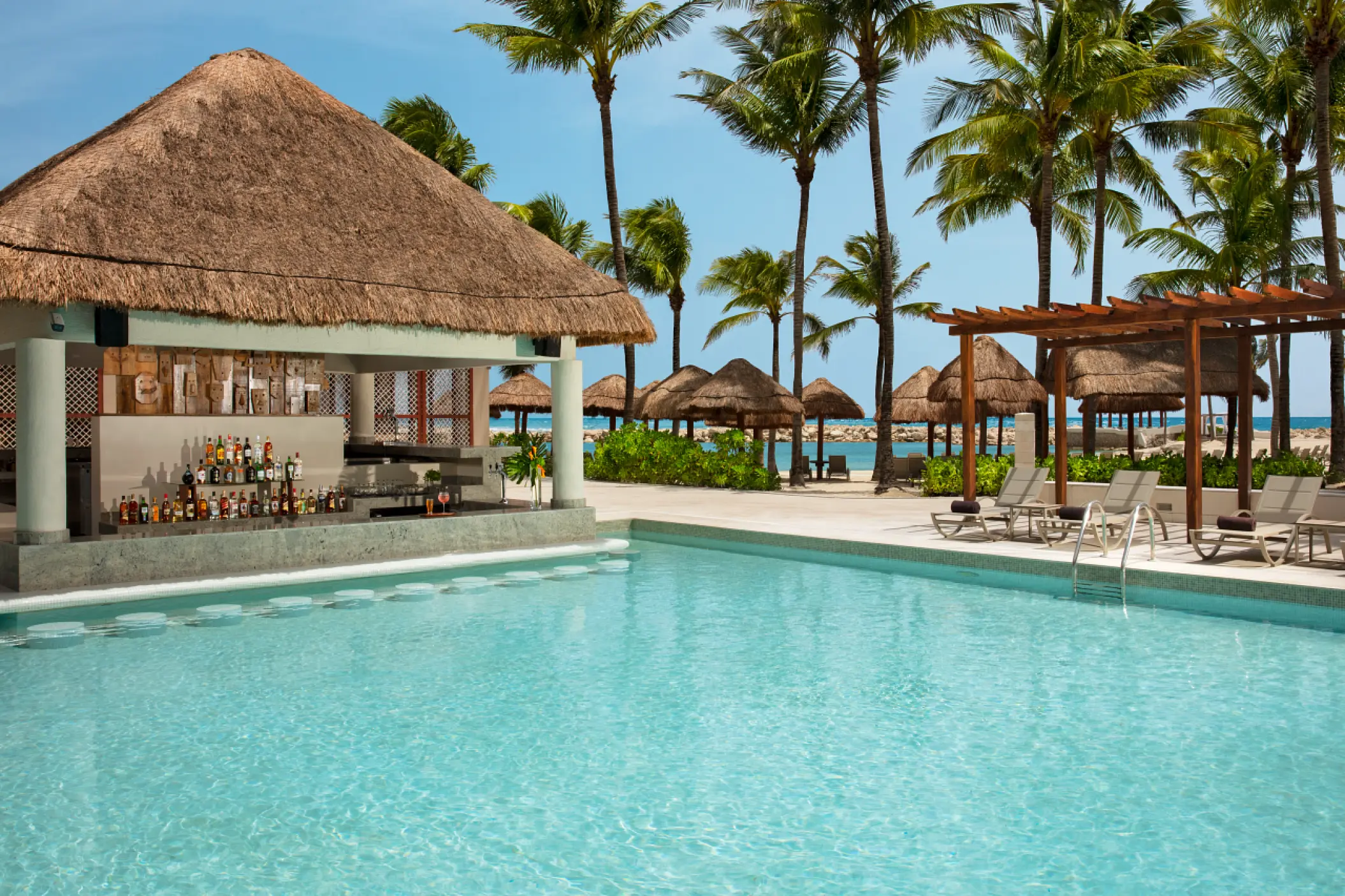 Swim-up bar with thatched roof at Dreams Aventuras, Riviera Maya