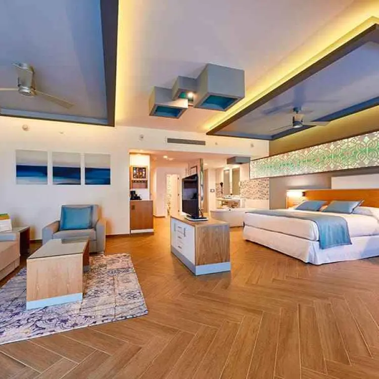 Modern suite with a king bed and separate sitting area at Riu Palace Costa Mujeres, Cancun