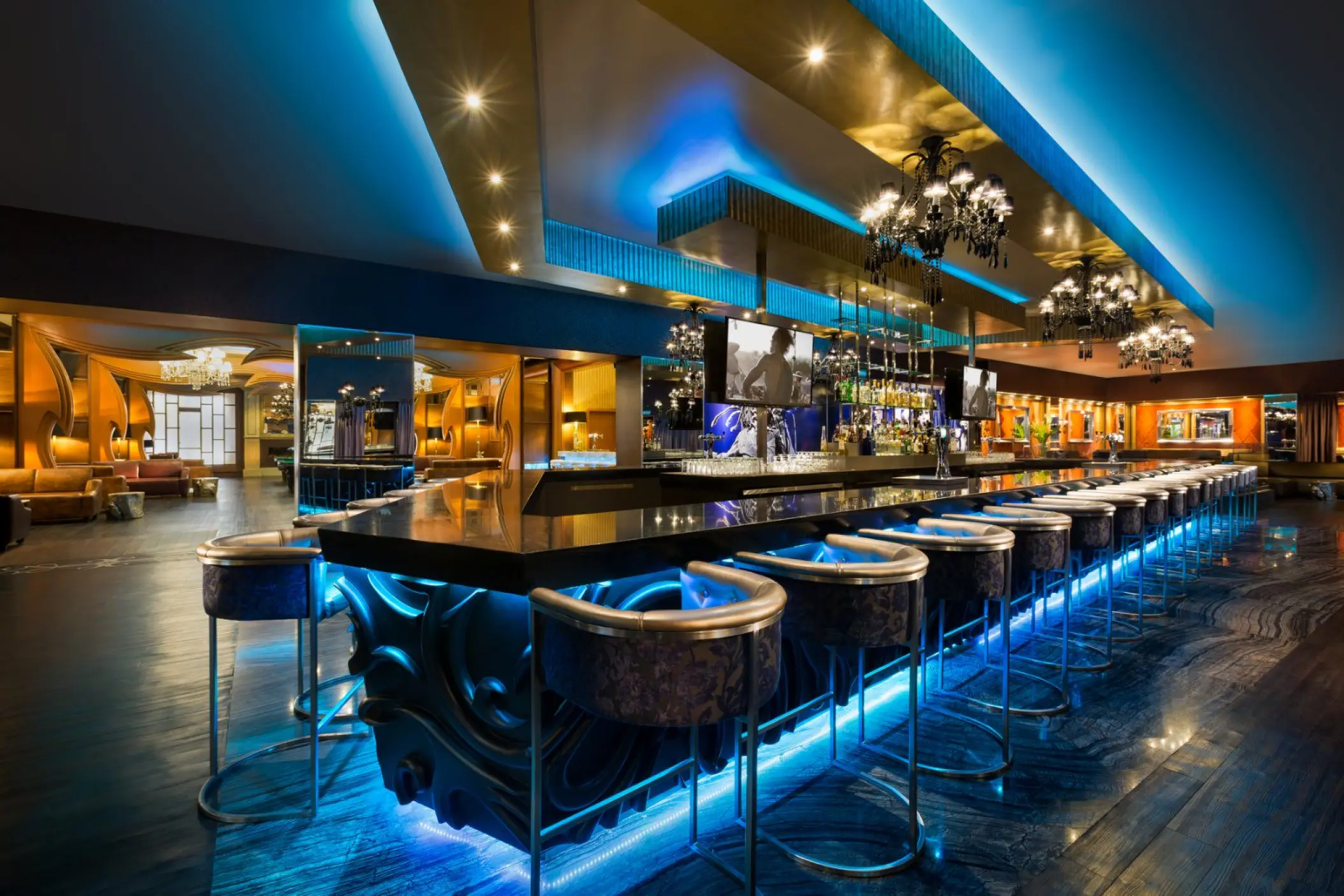 Modern cocktail lounge with blue neon lighting and a long black bar at Hard Rock Riviera Maya