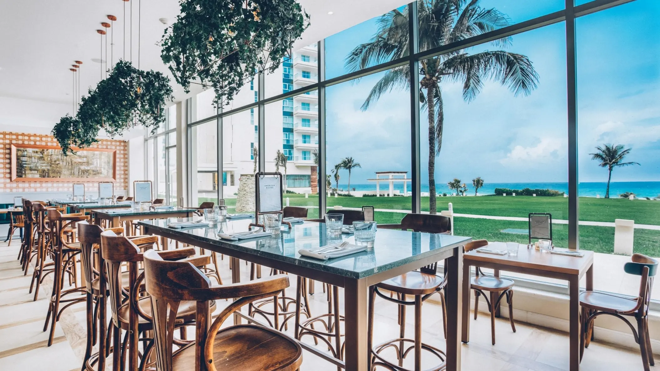 Modern restaurant with ocean views through floor-to-ceiling windows at Iberostar Selection Cancun