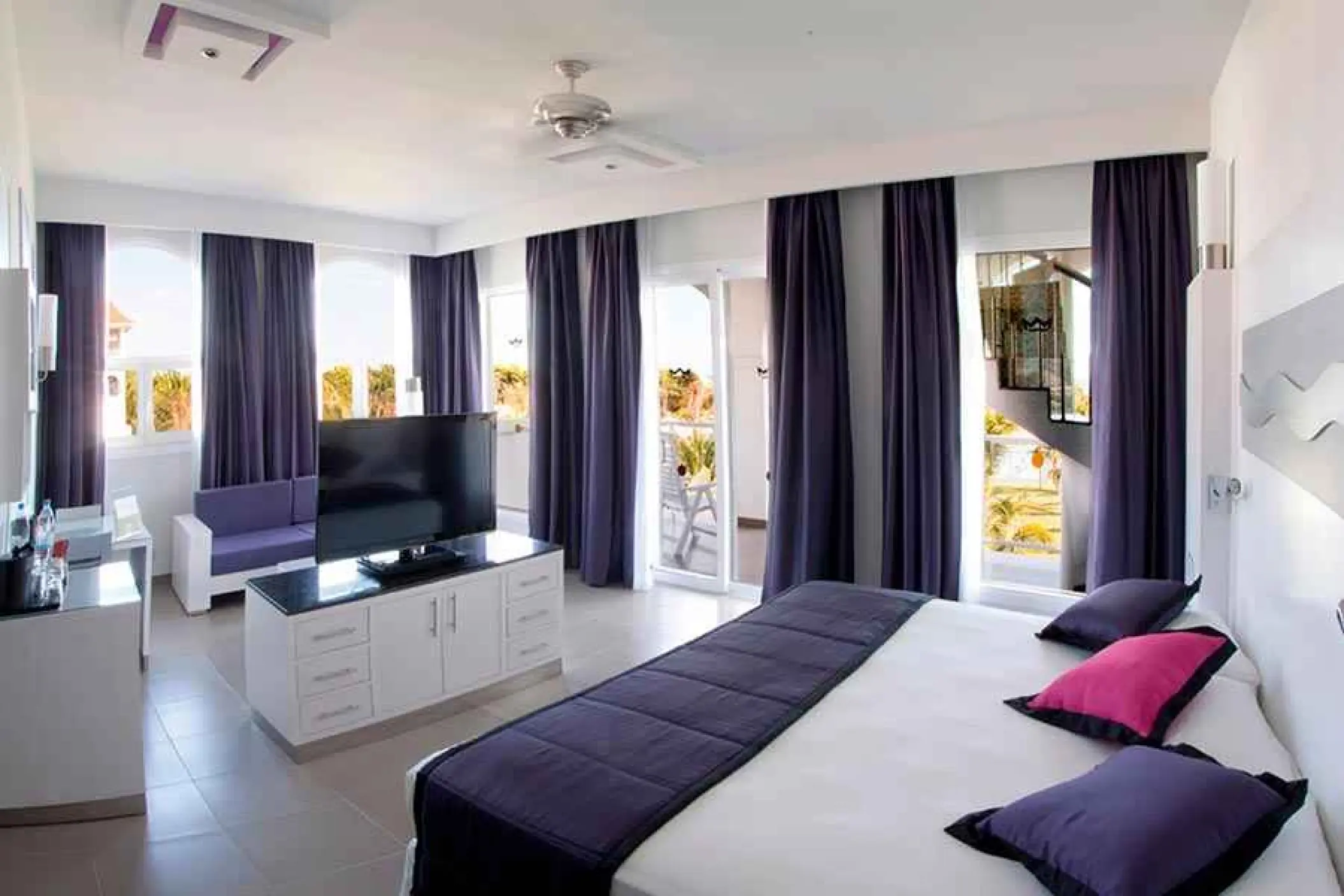 Modern guest suite with purple accents and private balcony at Riu Palace Mexico, Playa Del Carmen