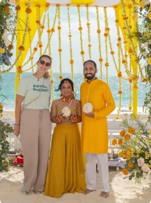 Paradise Weddings planner with a couple at a beachfront South Asian wedding ceremony