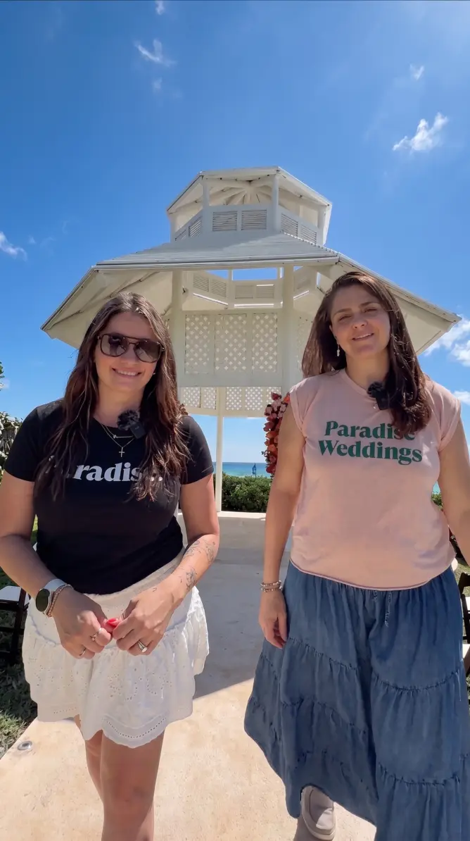 Paradise Weddings planners Eli and Lindsay standing in front of a white wedding gazebo