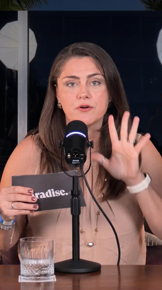 Paradise Weddings planner speaking into a microphone while holding a company card during a video recording
