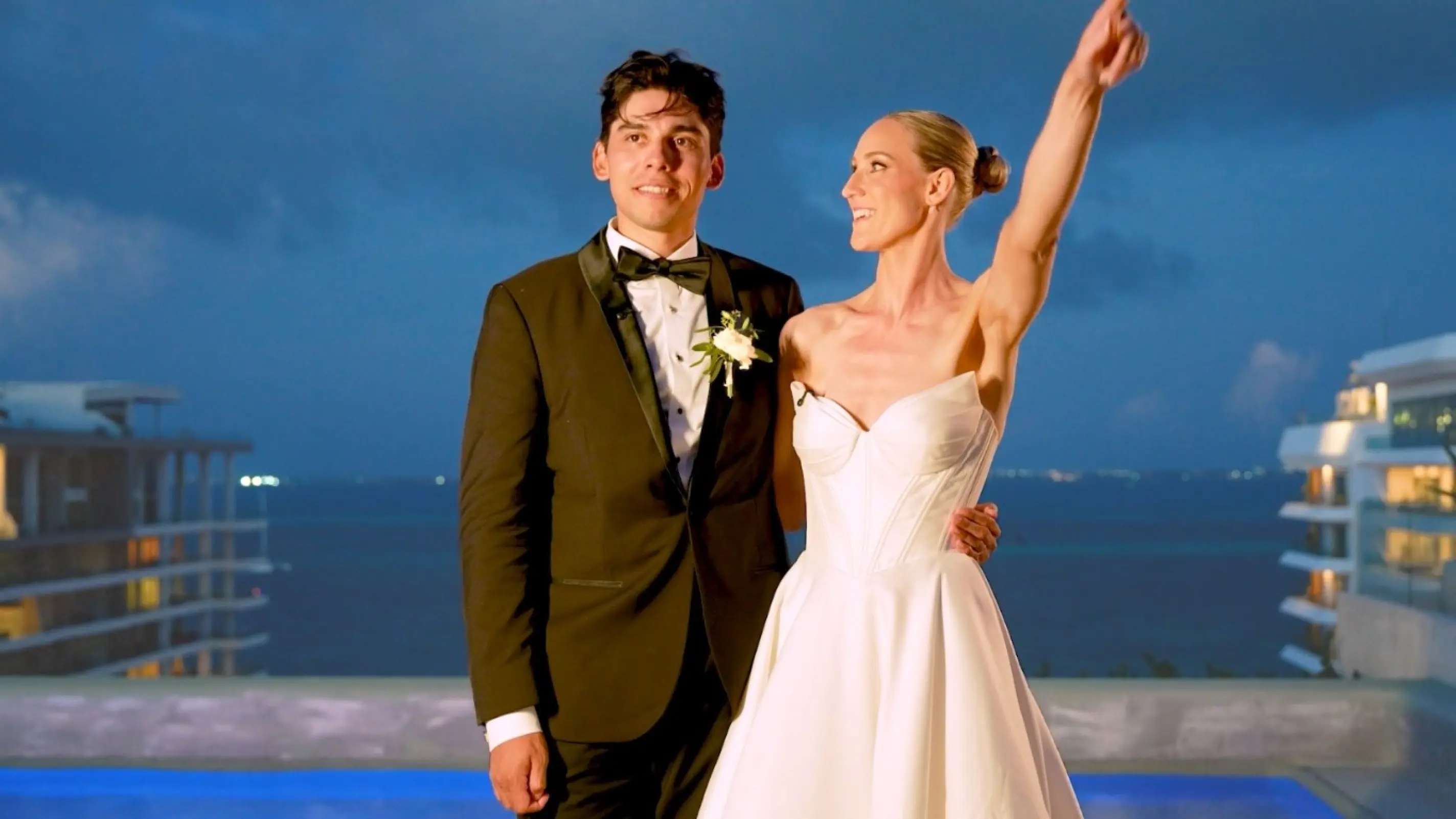 Sammy & Cristian celebrating at an evening wedding reception by an infinity pool