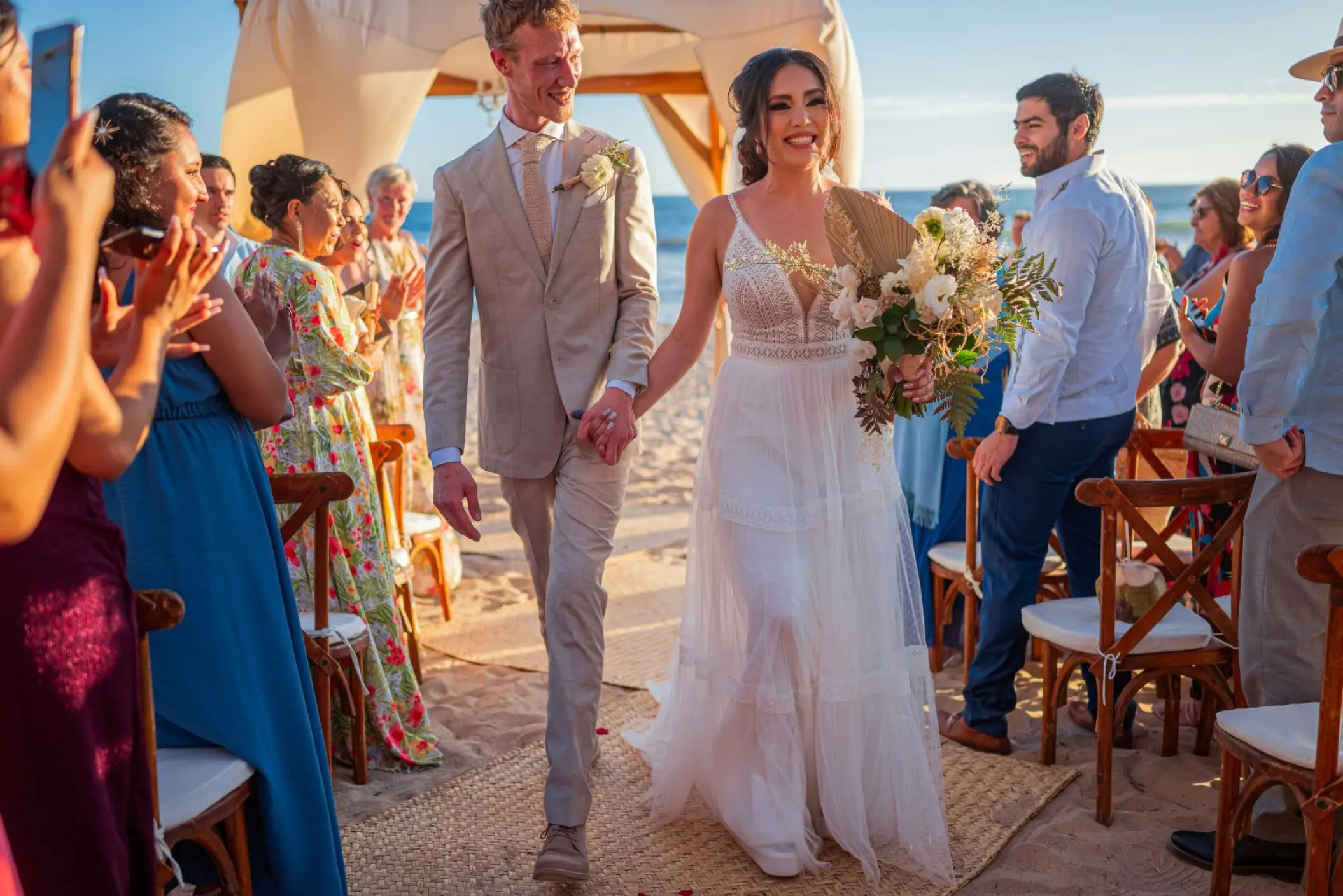 Newlyweds walking down the aisle after a beach ceremony at Royalton Blue Waters, Montego Bay