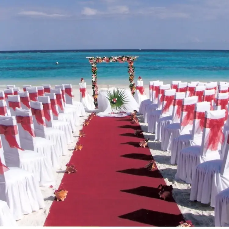 Beachfront wedding ceremony with red aisle runner and floral arch at Akumal Bay Beach Resort, Riviera Maya