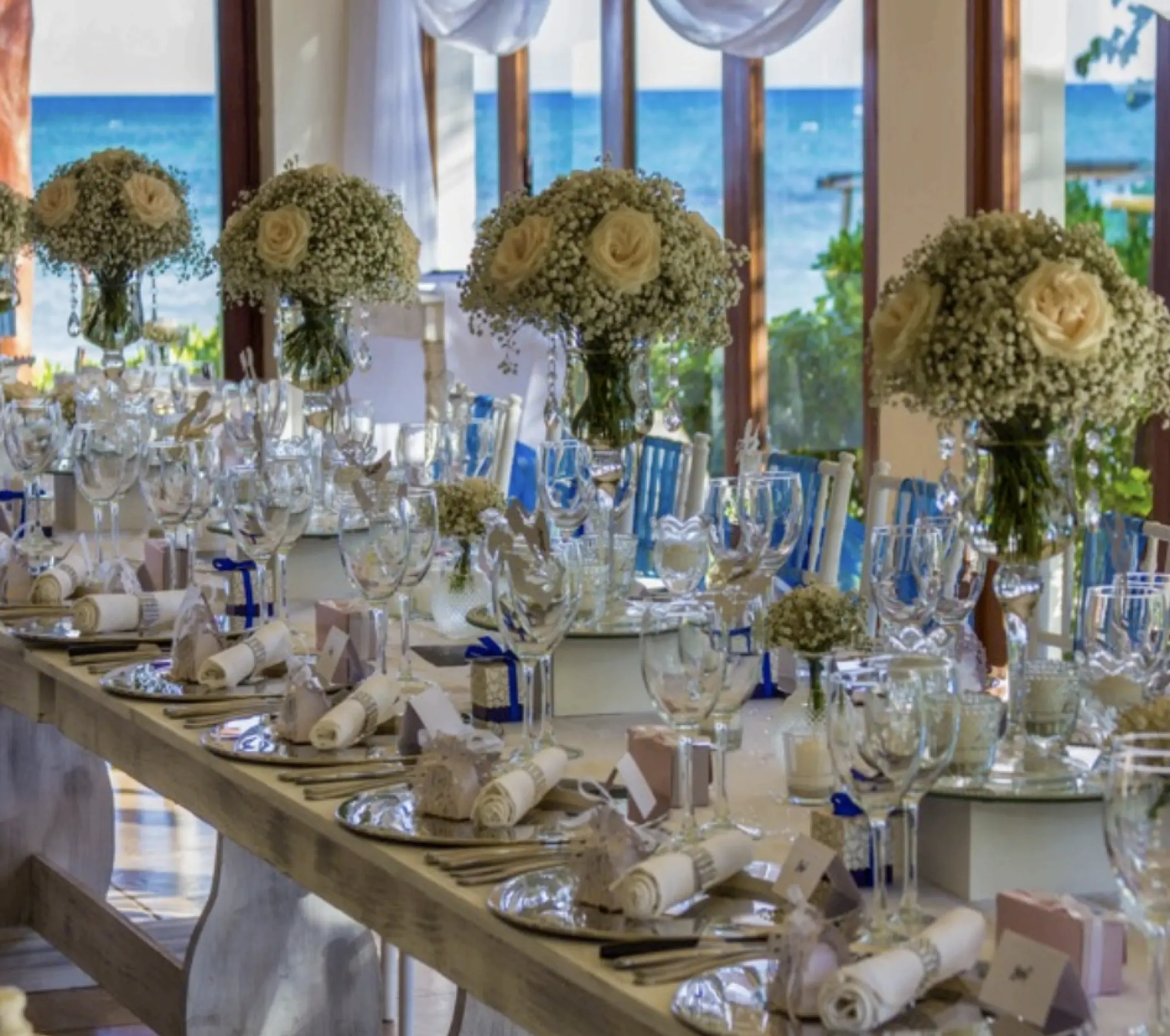 Long table wedding reception with baby's breath centerpieces at Akumal Bay Beach & Wellness, Riviera Maya