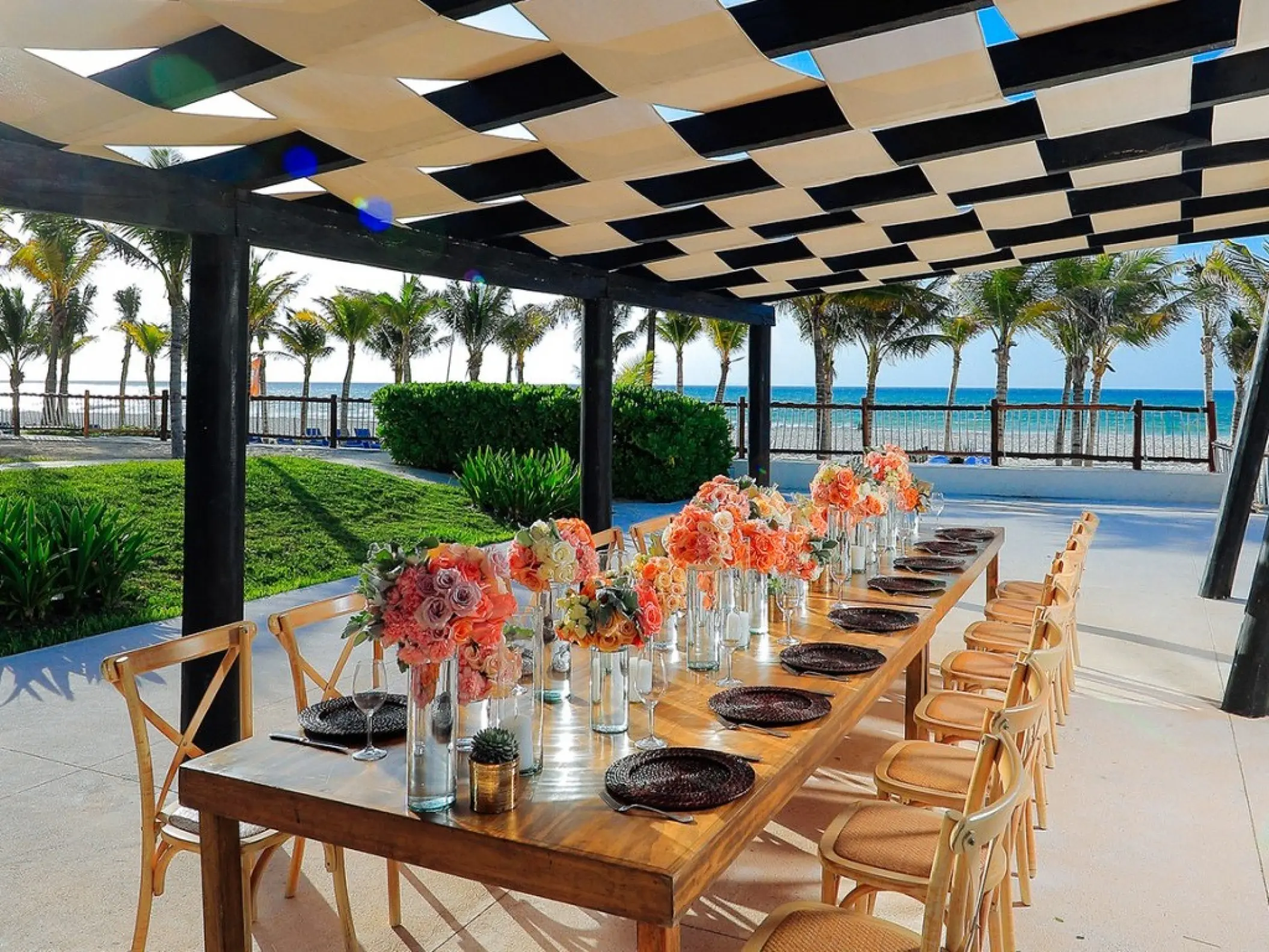 Wedding reception terrace with floral centerpieces and ocean views at Allegro Playacar, Playa Del Carmen