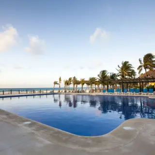 Allegro Playacar outdoor pool lined with palm trees and sun loungers, Playa Del Carmen