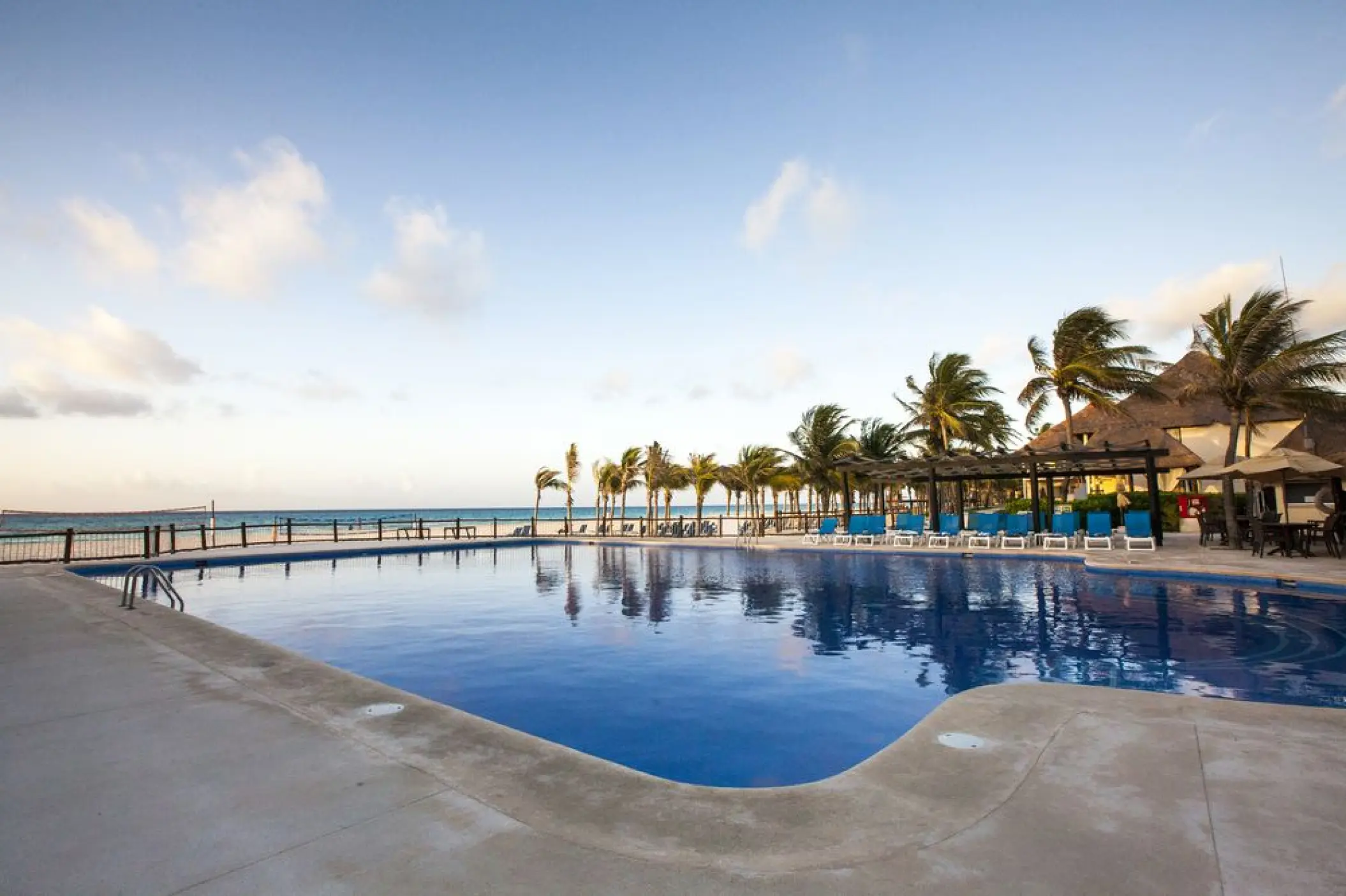 Allegro Playacar outdoor pool lined with palm trees and sun loungers, Playa Del Carmen