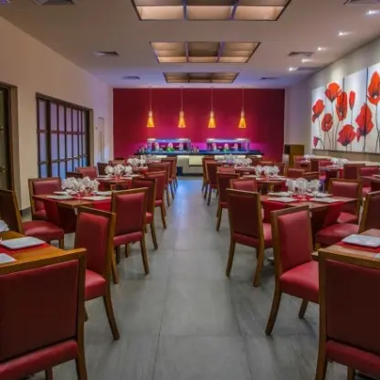 Indoor wedding reception venue with red chairs and floral wall art at Allegro Playacar, Playa Del Carmen