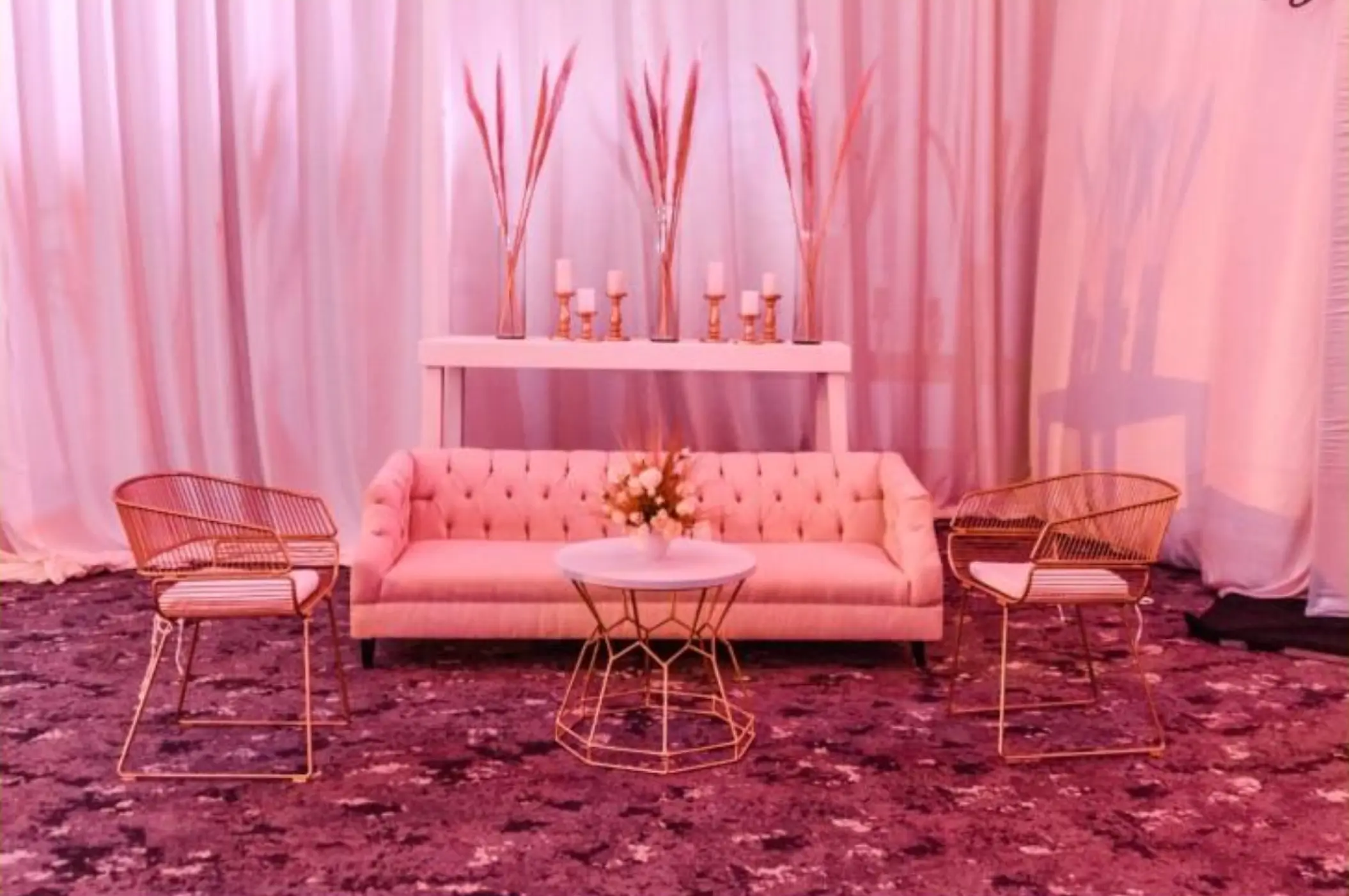 Indoor wedding lounge setup with pink sofa and gold chairs at Atelier Playa Mujeres, Cancun