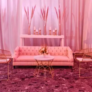 Indoor wedding lounge setup with pink sofa and gold chairs at Atelier Playa Mujeres, Cancun