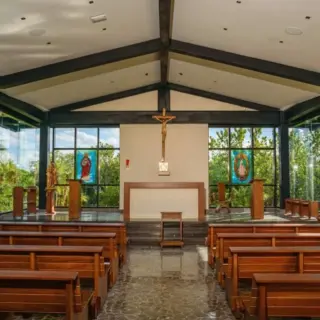 Modern wedding chapel with glass walls and wooden pews at Atelier Playa Mujeres, Cancun