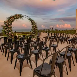 Rooftop wedding ceremony setup with black chairs and floral arch at Atelier Playa Mujeres, Cancun