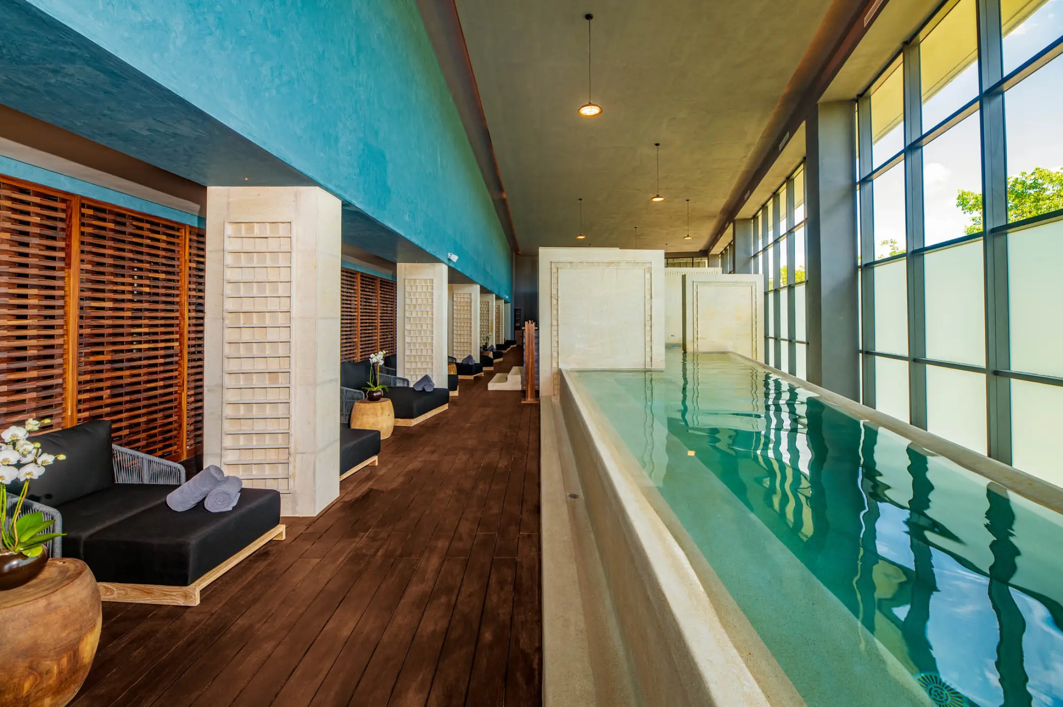Indoor spa pool with lounge chairs at Atelier Playa Mujeres, Cancun
